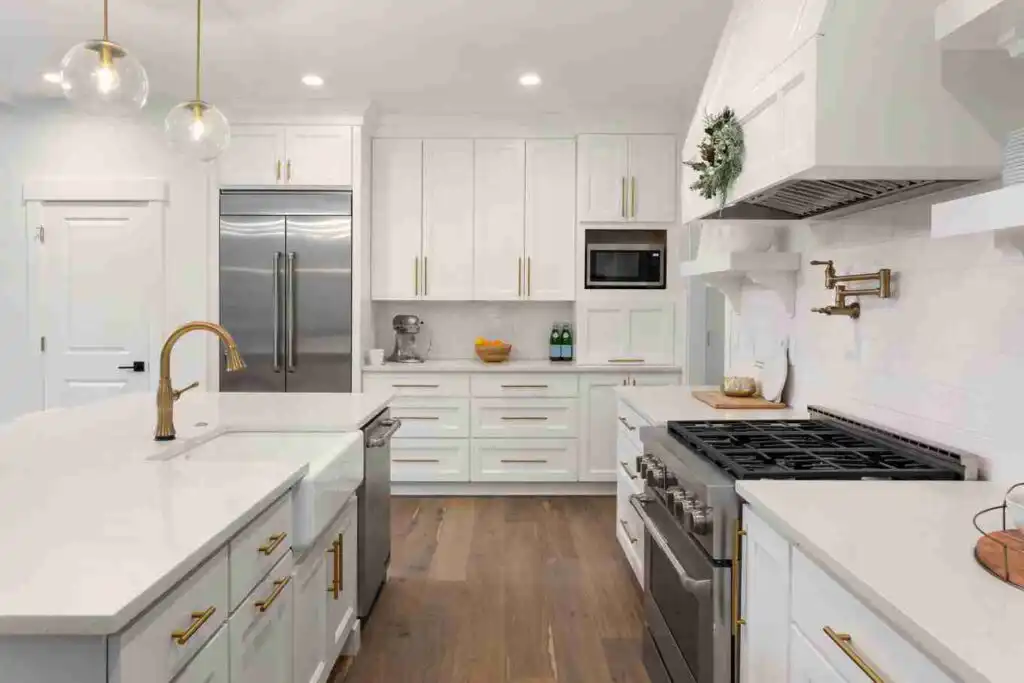White shaker kitchen cabinets with brass hardware and quartz countertops in Kelowna