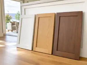 Shaker cabinet doors leaning side by side in different finishes — painted white, natural white oak, walnut stain — all showing the... | Holz Industries, Kelowna