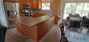 Cherry wood kitchen cabinetry with island and stainless appliances